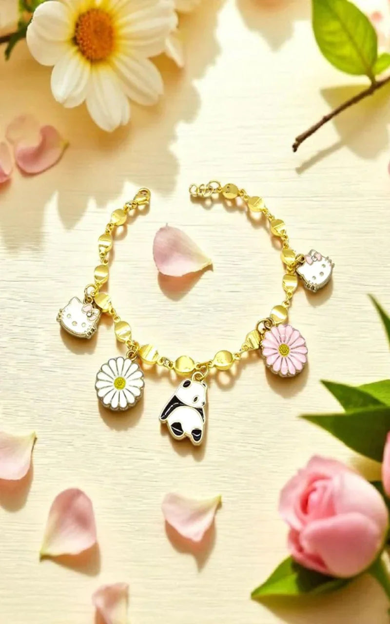 Gold bracelet with charms on a light background with flowers and petals