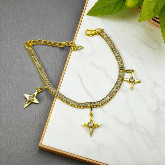 Gold bracelet with star charms on a white surface