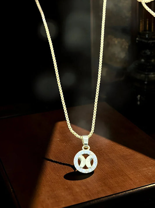 Gold necklace with a circular pendant on a wooden surface