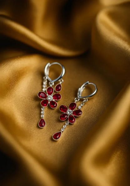Floral earrings with red gemstones on a brown fabric background