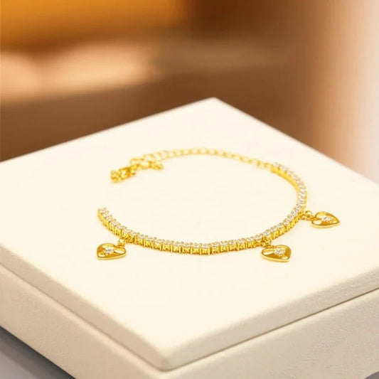 Gold bracelet on a white box with a warm background