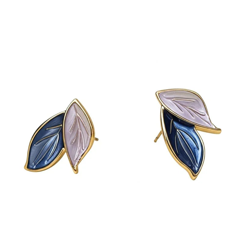 Pair of leaf-shaped earrings with gold accents on a white background