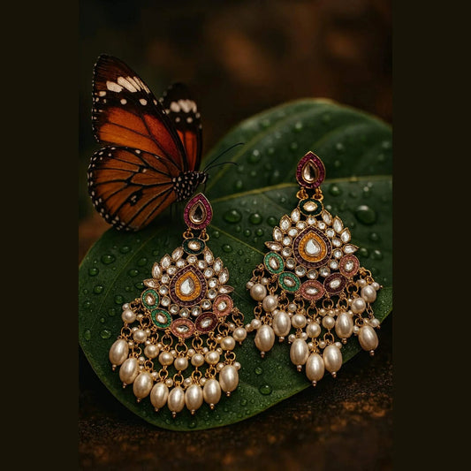 Ornate earrings with pearls on a green leaf with a butterfly.