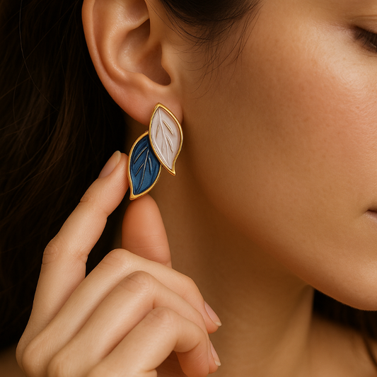 Close-up of a woman wearing a gold and blue leaf-shaped earring.
